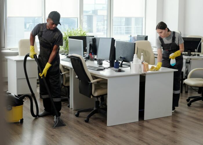 young-man-woman-using-detergent-vacuum-cleaner-cleaning-openspace-office